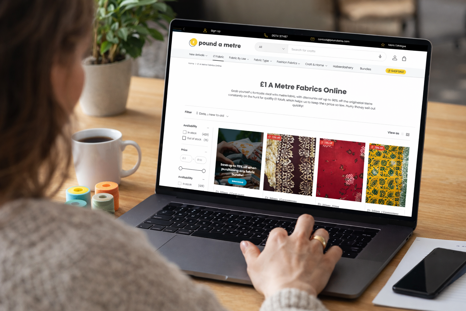 Woman browsing the Pound A Metre £1 fabrics page on a laptop, preparing to order fabric onlin